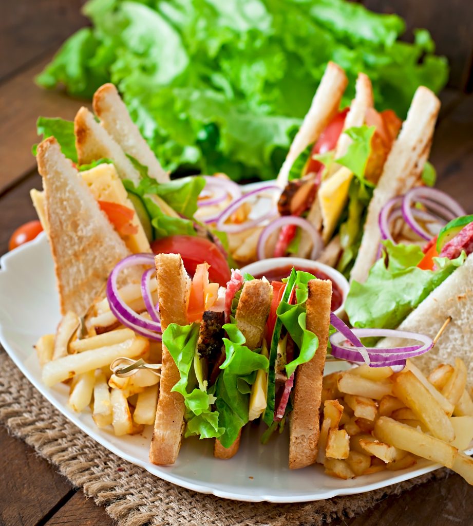 club-sandwich-with-cheese-cucumber-tomato-smoked-meat-salami-served-with-french-fries